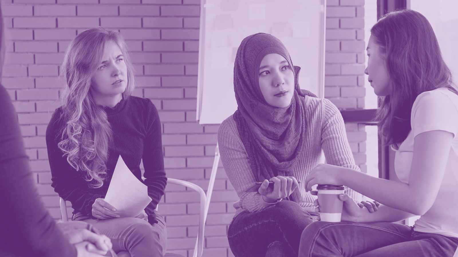 Three young women sitting down and having a conversation