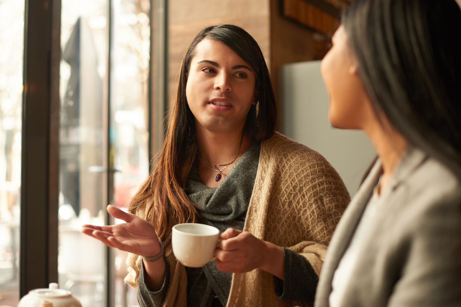 Two women talking and holding cups