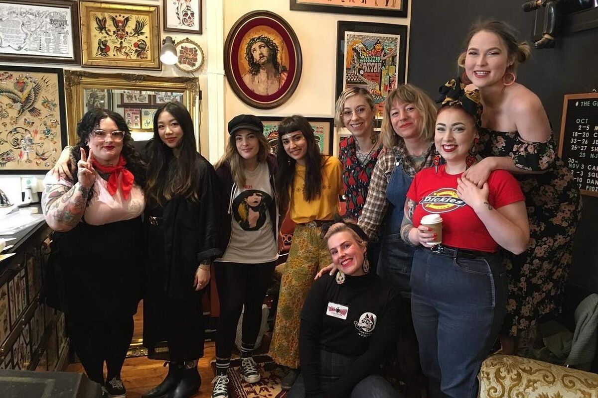 9 women smiling in tattoo shop