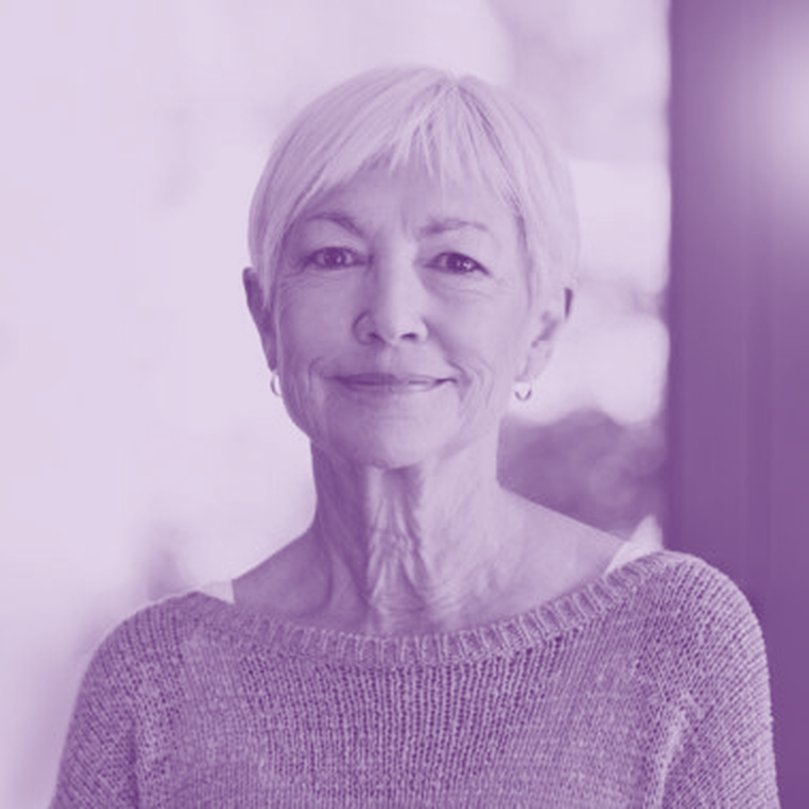 Middle aged woman smiling at camera purple
