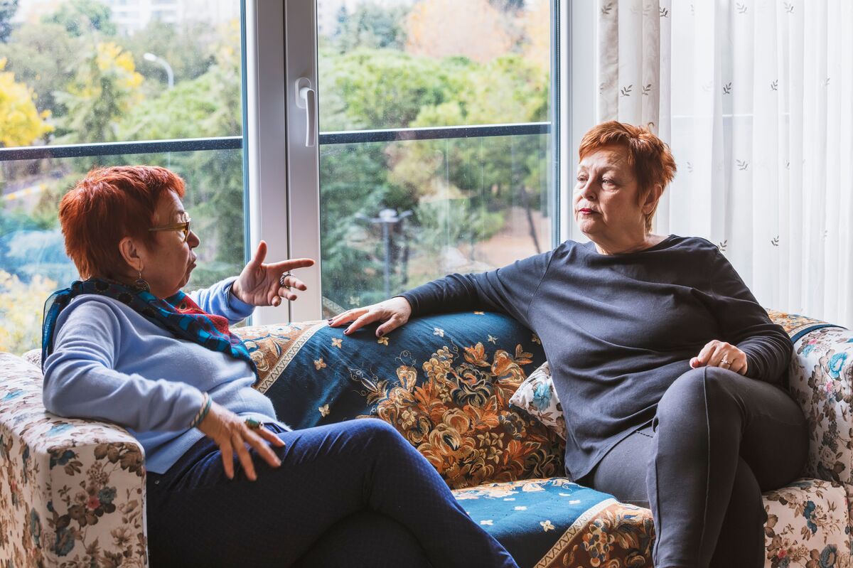 two older women talking on a couch