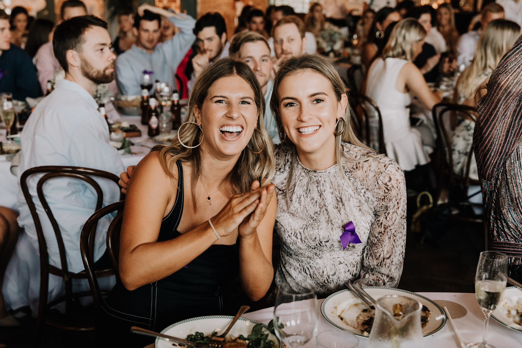 Two women seated at a table smiling